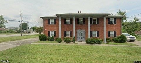 A red brick house with a grey door and windows.