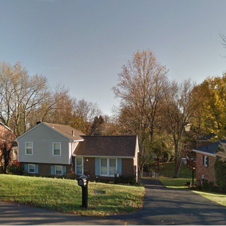 A residential street with two houses and a mailbox.