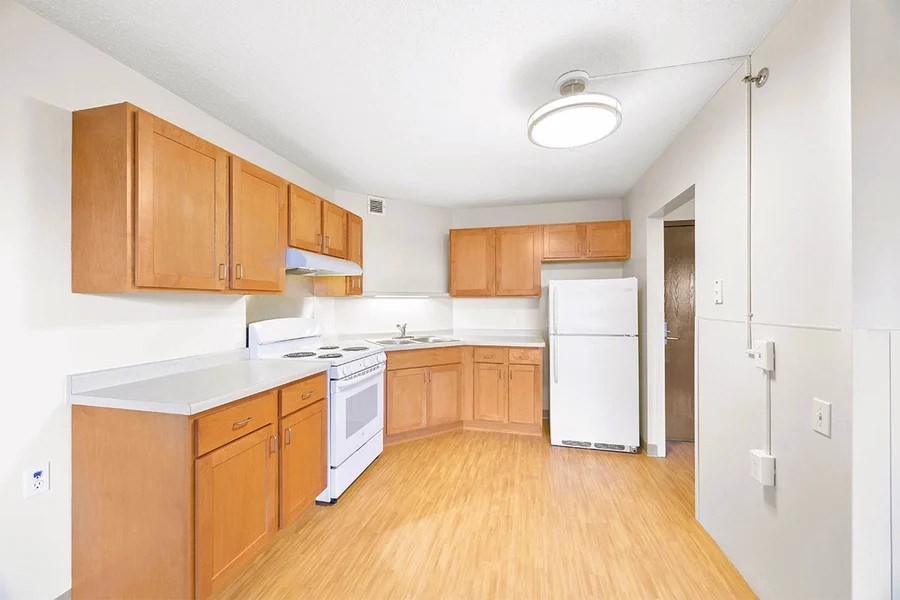 A kitchen with wooden cabinets and white appliances.