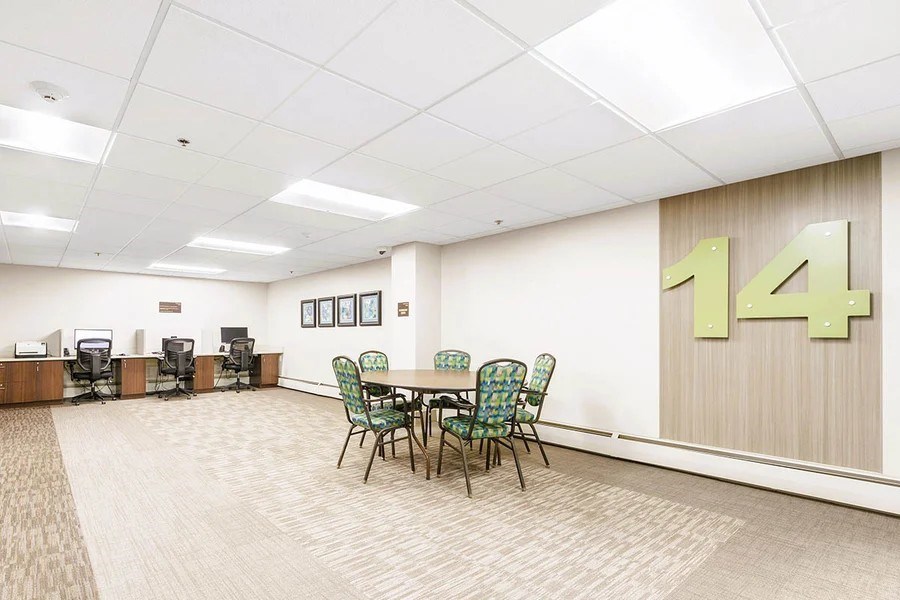 A conference room with a table and chairs and a number 14 on the wall.