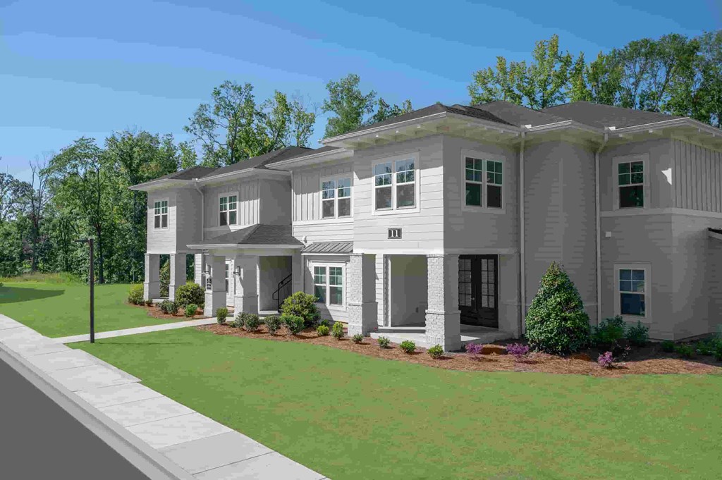 A modern two-story house with a front yard and landscaping.