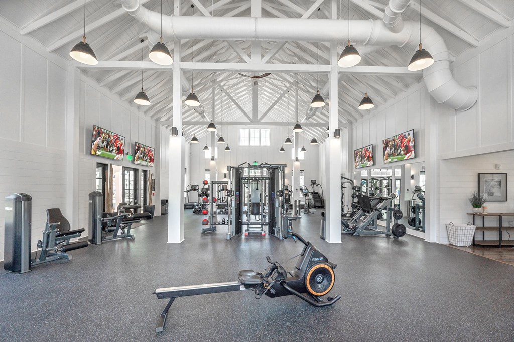 A gym with a variety of equipment including a rowing machine.