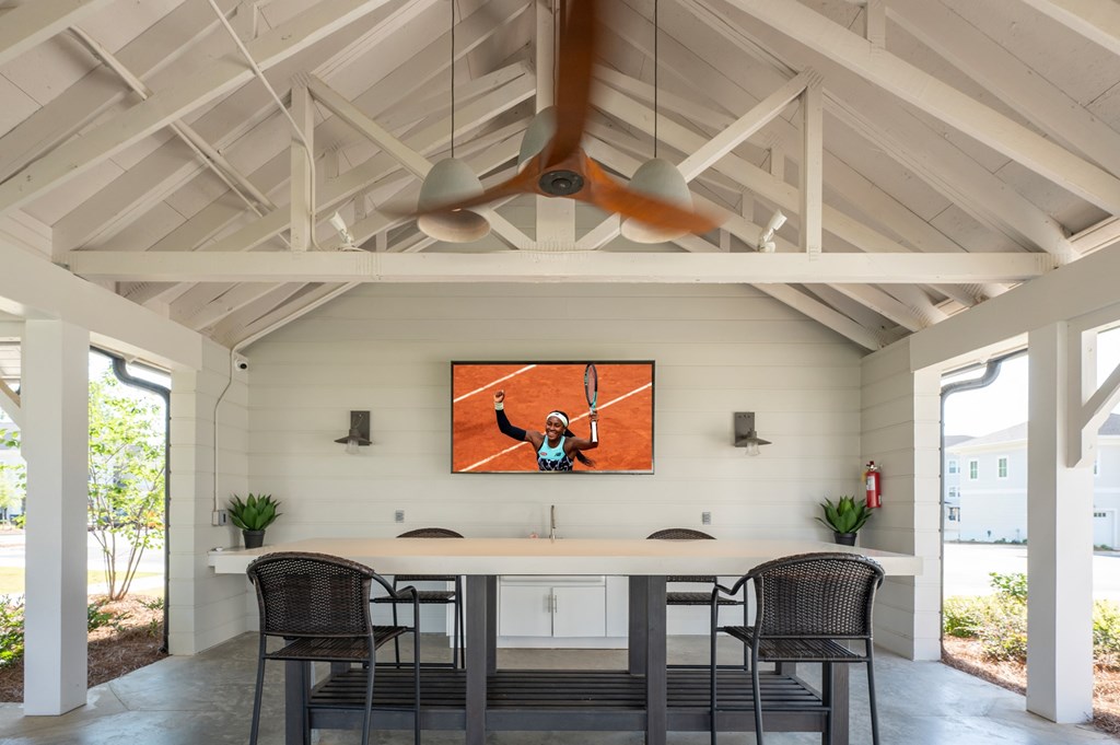 A large painting of a man playing tennis hangs on a wall above a kitchen island.