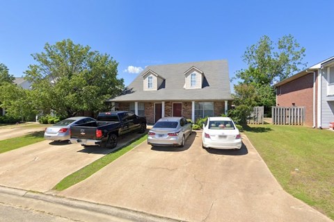 A house with a grey roof and a white car parked in front.