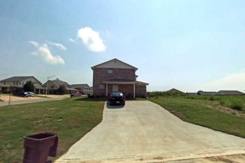 A car is parked on a driveway in front of a house.