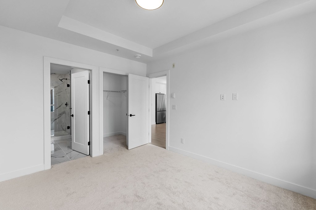 A white room with a carpeted floor and a ceiling light.