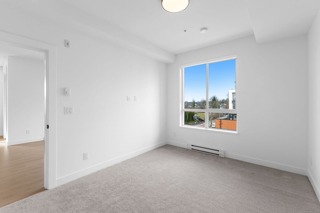 A large empty room with a window overlooking a cityscape.