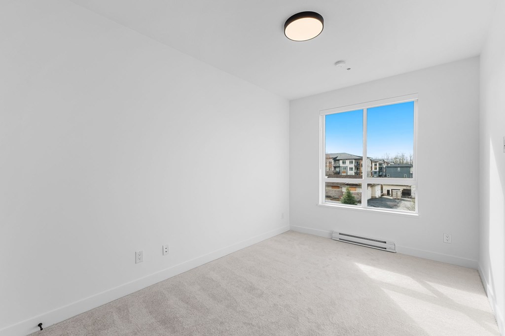 A room with a large window and a picture on the wall.