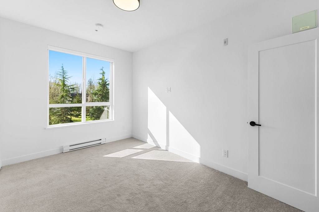A room with a large window and a white door.