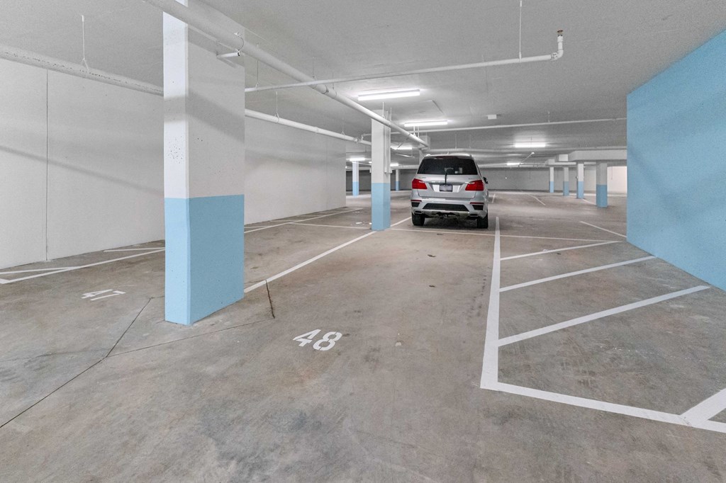 A parking garage with a Mercedes-Benz SUV parked in spot 48.