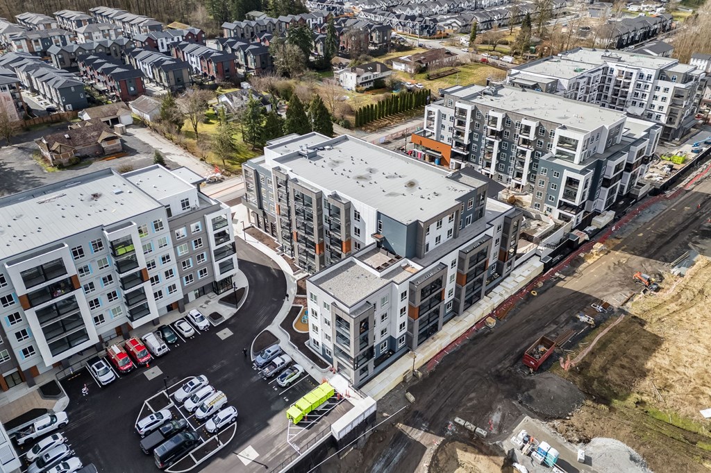 A parking lot is surrounded by apartment buildings.