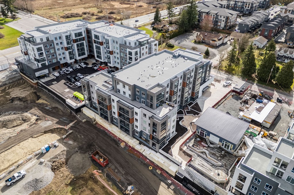 A large building complex under construction with a lot of dirt and debris around it.