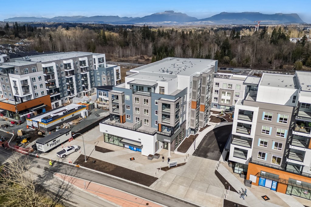 A modern apartment complex with a parking lot in front.