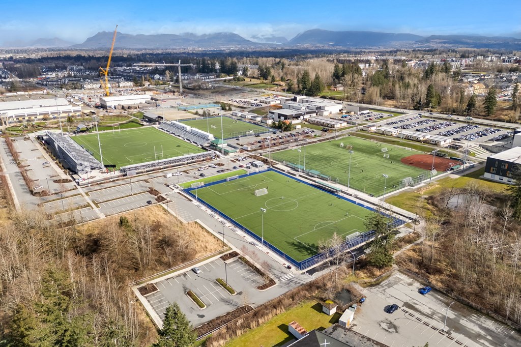 A large sports complex with multiple fields and a mountain in the background.