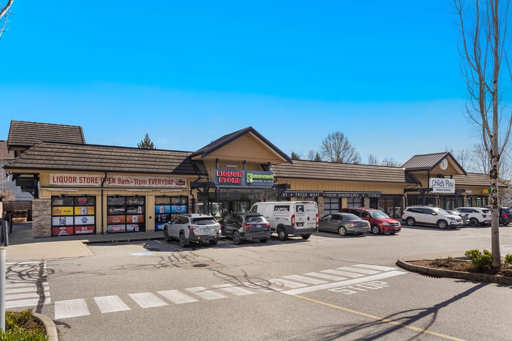 A liquor store with a sign that says "Open 9am-7pm Everyday" is in front of a parking lot.