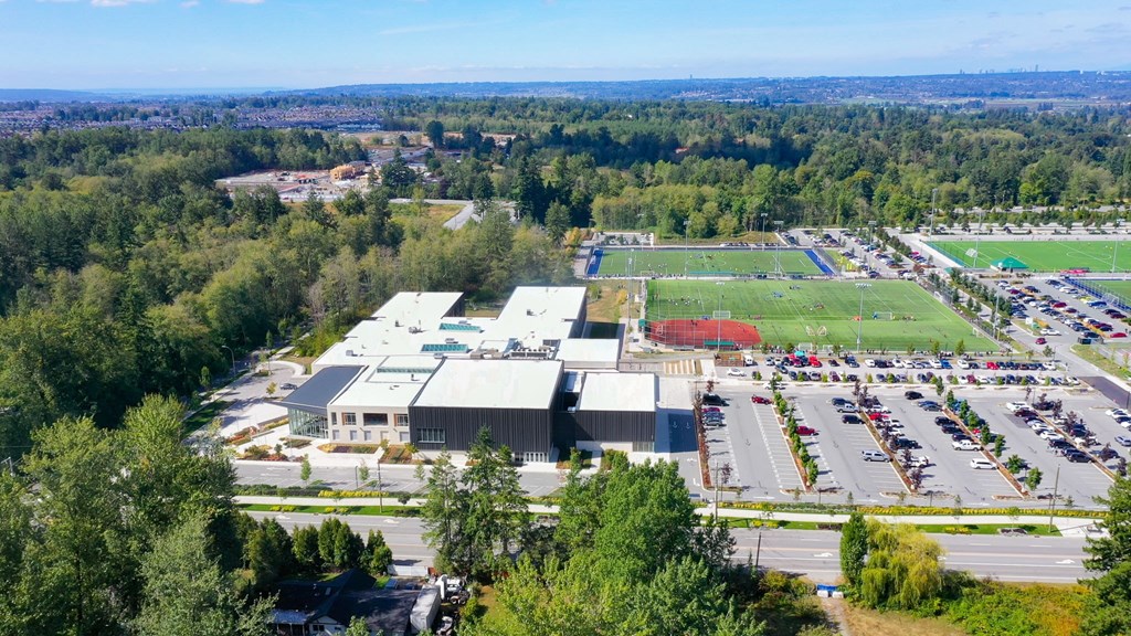 A large industrial building with a parking lot in front.