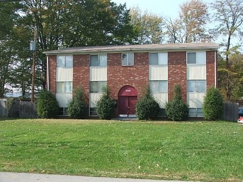 A red brick building with a red door and white trim.
