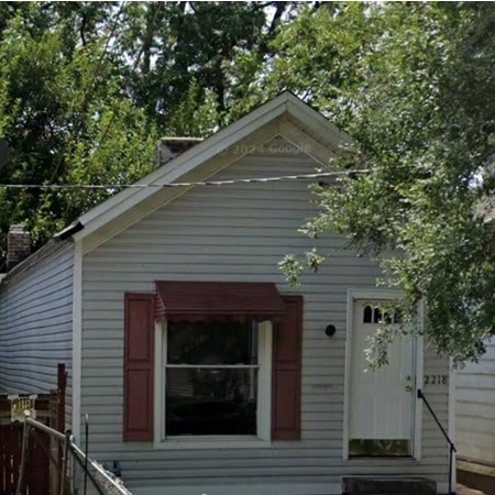 A small house with a red window trim and a white door.
