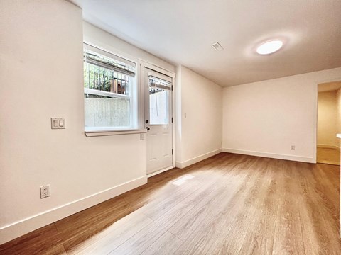 A room with a window and wooden flooring.