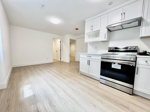 A kitchen with white cabinets and a stainless steel stove.