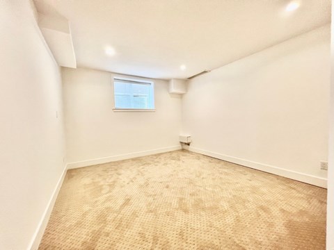 A room with a carpeted floor and a window.