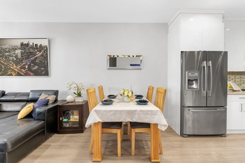 A modern kitchen with a dining table set for four.
