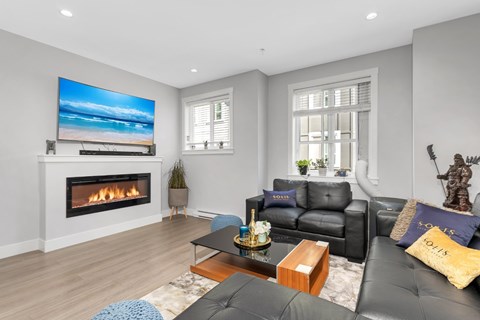 A modern living room with a fireplace and a large TV.