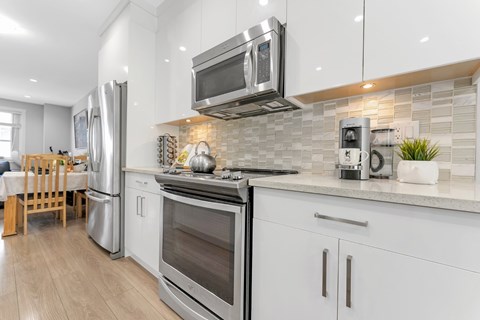 A modern kitchen with stainless steel appliances and white cabinets.
