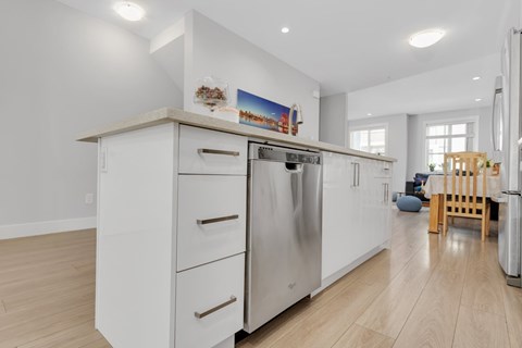 A modern kitchen with a refrigerator, oven, and cabinets.