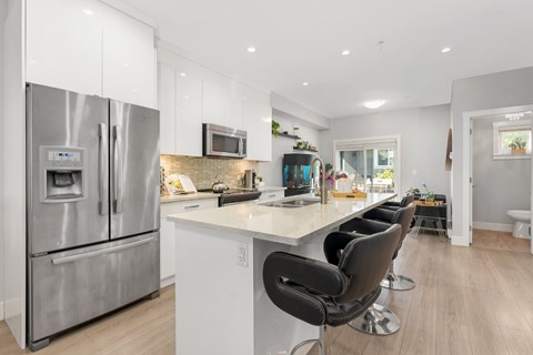 A modern kitchen with a stainless steel refrigerator and white countertops.