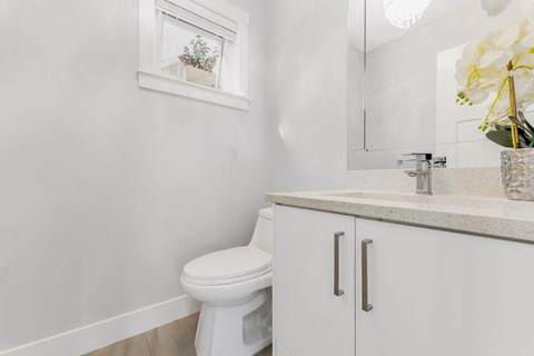 A white toilet sits next to a white cabinet in a bathroom.