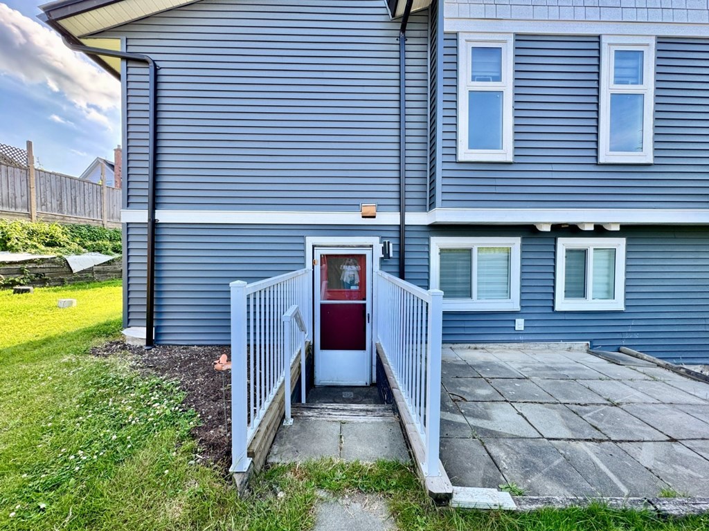 A blue house with a red door and a white fence.