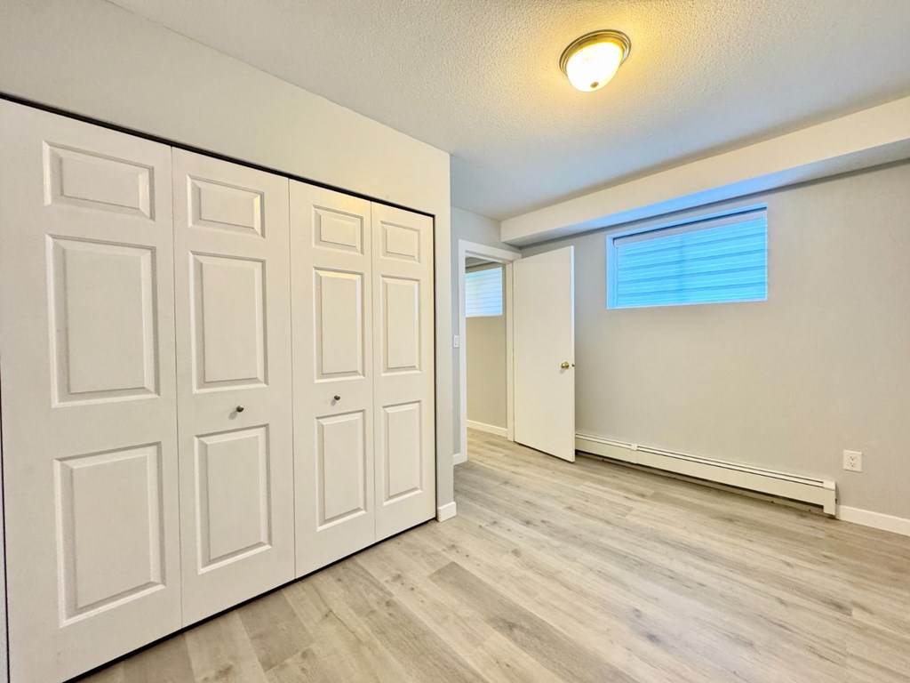 A room with white doors and a window with blinds.