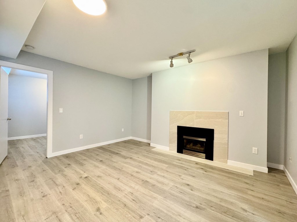 A room with a fireplace and wood flooring.