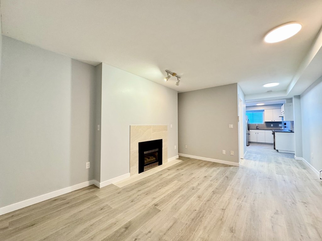 A spacious living room with a fireplace and hardwood flooring.