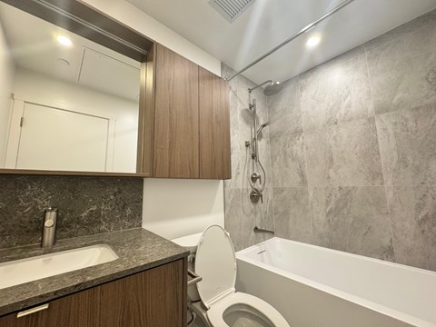 A bathroom with a toilet, sink, and bathtub.