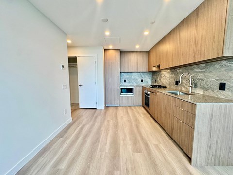 A kitchen with wooden floors and cabinets.