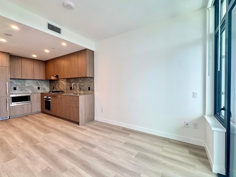 A kitchen with wooden cabinets and a marble backsplash.