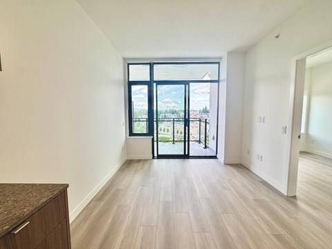 A room with a large window and sliding glass doors.