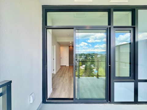 A modern house with a glass door leading to a hallway.