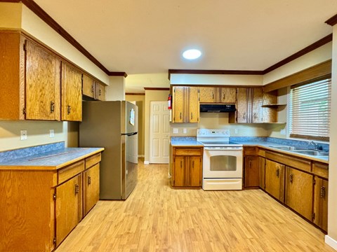 A kitchen with wooden cabinets and a refrigerator.