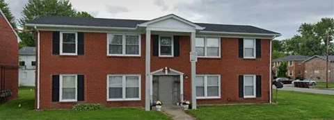 A red brick house with a grey roof and a grey door.
