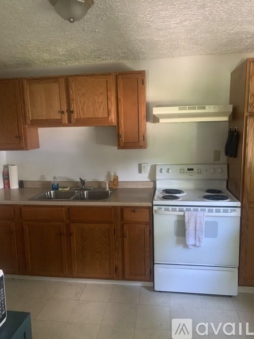 A kitchen with wooden cabinets and a white oven.
