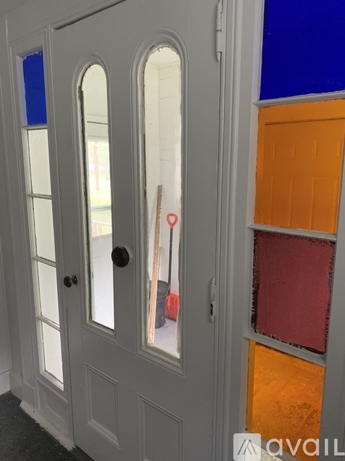 A grey door with a black handle and a glass window.