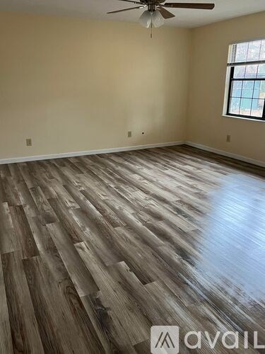 A room with wooden flooring and a ceiling fan.