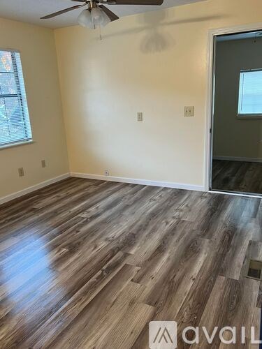 A room with wooden flooring and a ceiling fan.