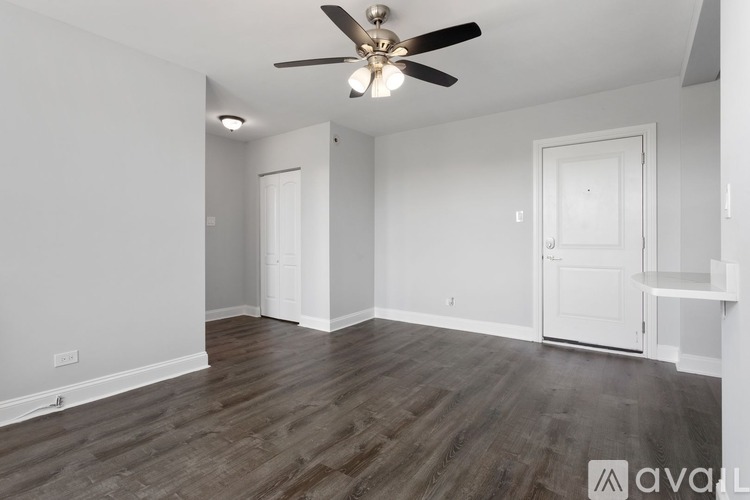 A room with a ceiling fan and wooden flooring.