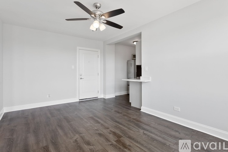 A room with a ceiling fan and wooden flooring.
