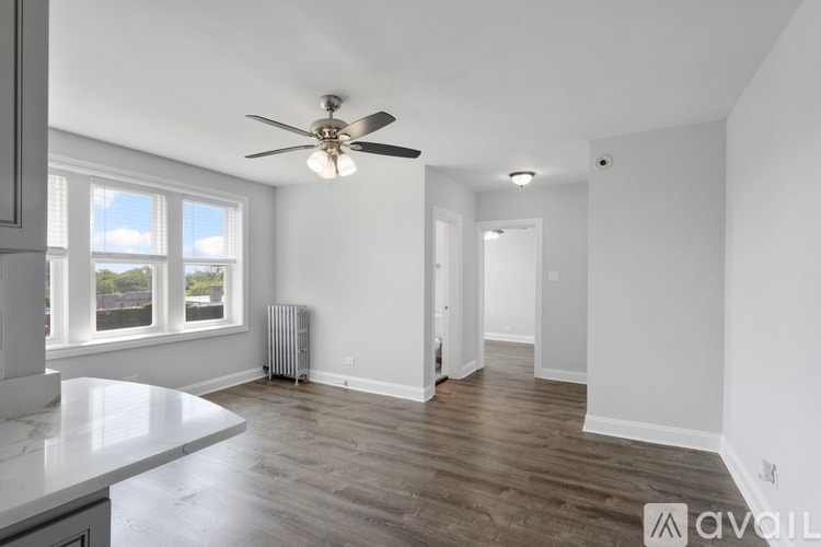 A spacious room with a ceiling fan and a window overlooking the outdoors.