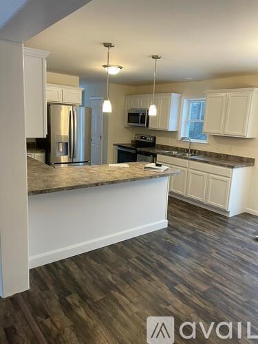 A kitchen with a granite countertop and white cabinets.
